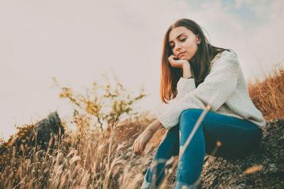 Femme triste consciente assise dans la nature